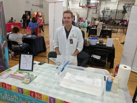 a person standing next to a table with a variety of objects on it