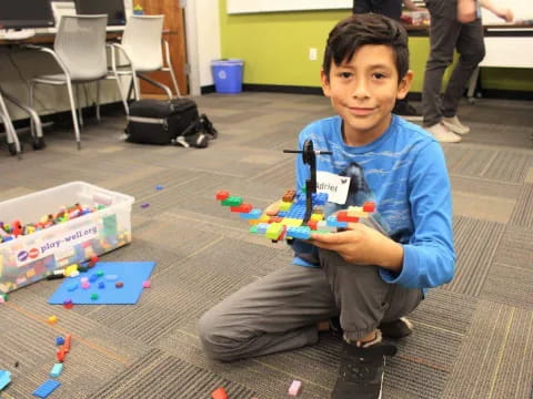 a boy sitting on the floor holding a toy