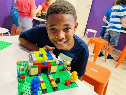 a boy sitting at a table with toys