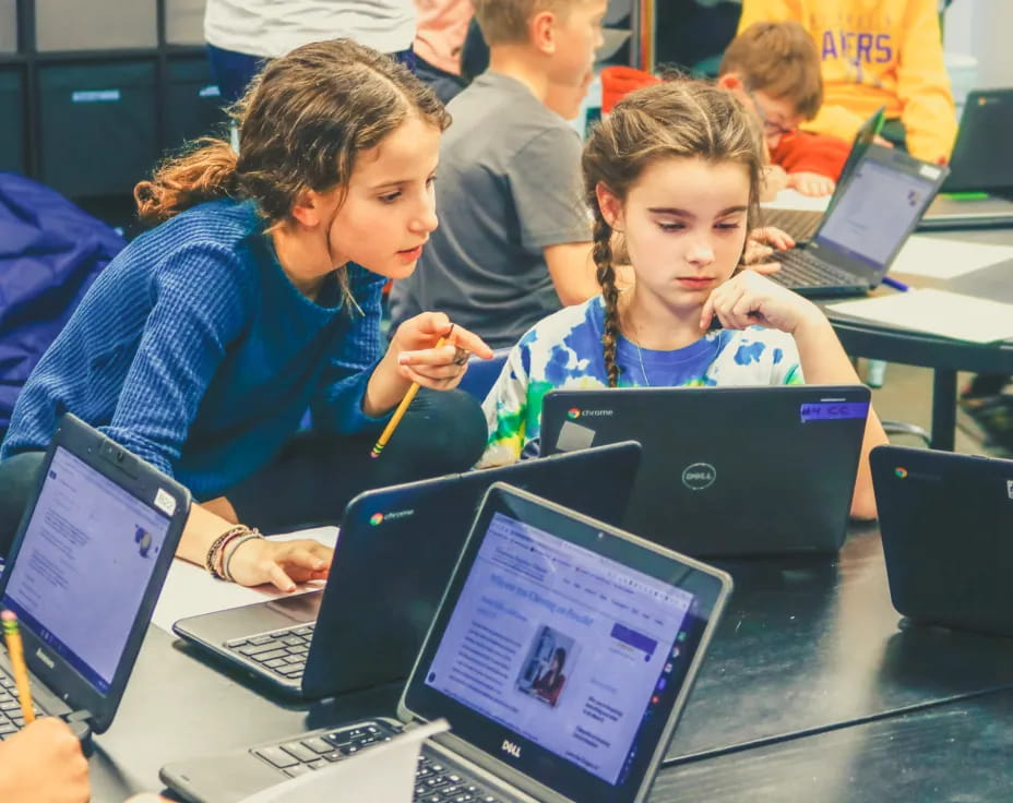 a few children using laptops