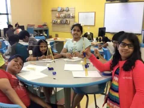 a group of children sitting at a table