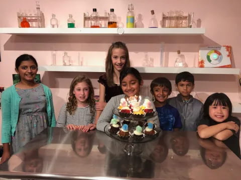 a group of people posing for a photo with a cake