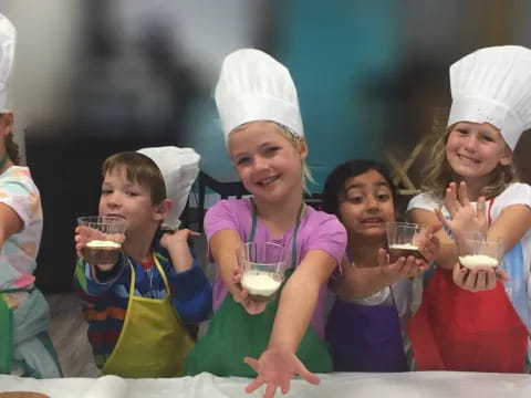 a group of people wearing aprons and holding cups of liquid