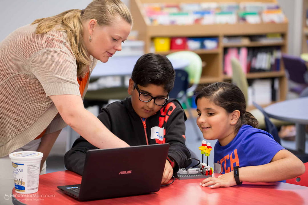 a man and a couple of kids looking at a laptop