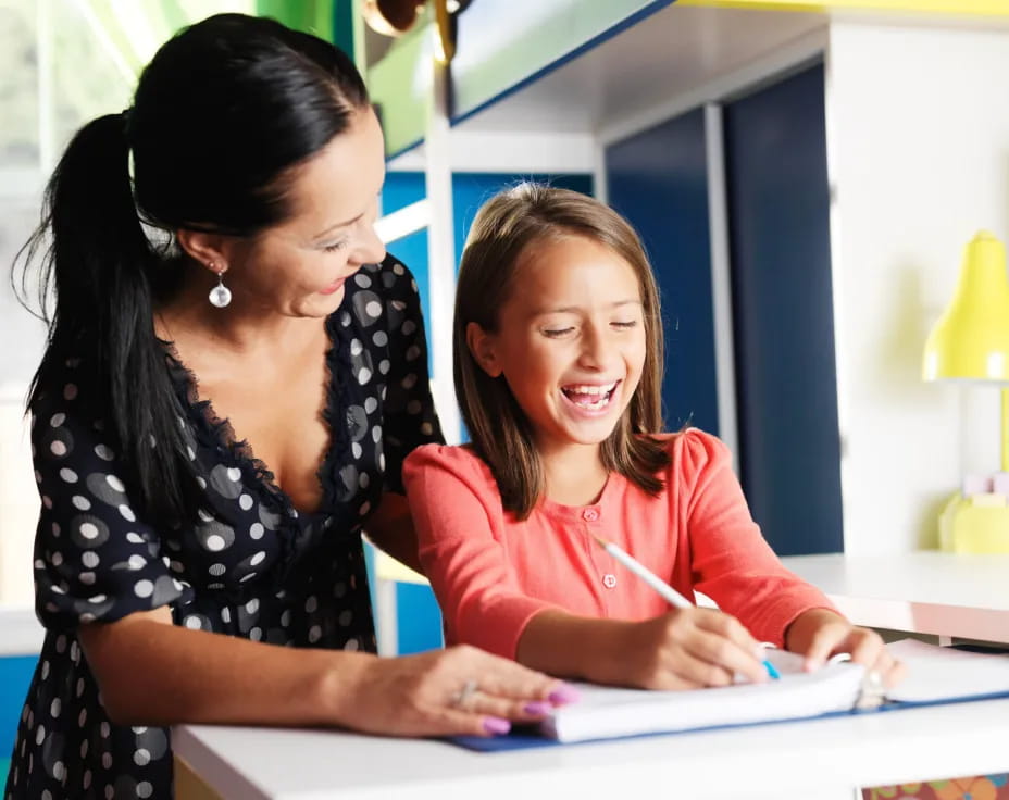 a woman showing a girl something on the paper