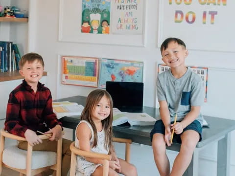 a group of children sitting at a table in a classroom