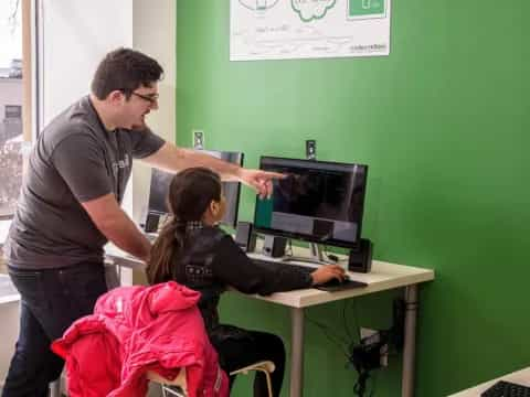 a man showing a woman something on the computer