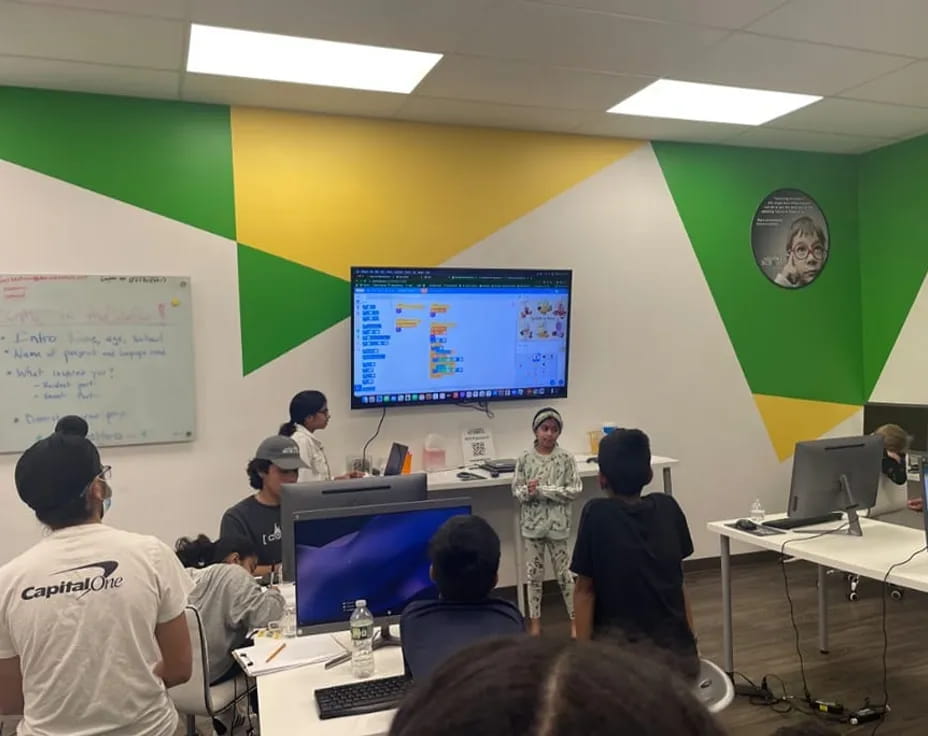 a group of people in a room with computers and a projection screen