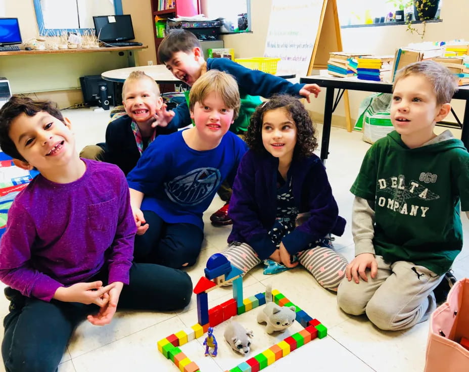 a group of children sitting on the floor with a puzzle