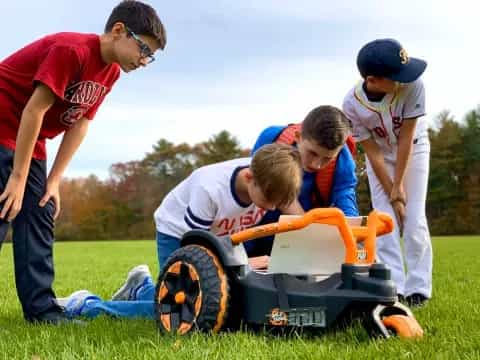 a group of people working on a small vehicle