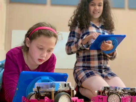 a young girl and a young girl playing with a toy train