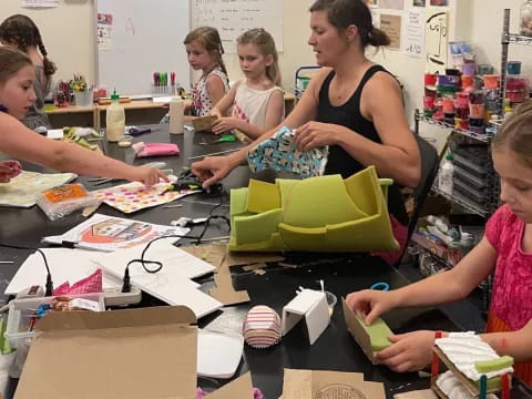 a group of people sitting at a table with boxes and papers