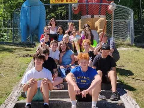 a group of people posing for a photo in front of a statue