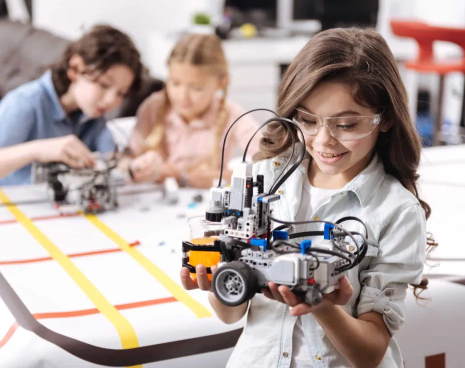 a group of children playing with a toy car