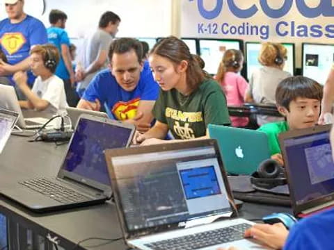 a group of people using laptops