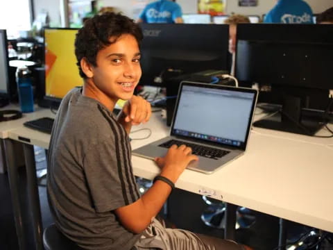 a man sitting at a desk with a laptop