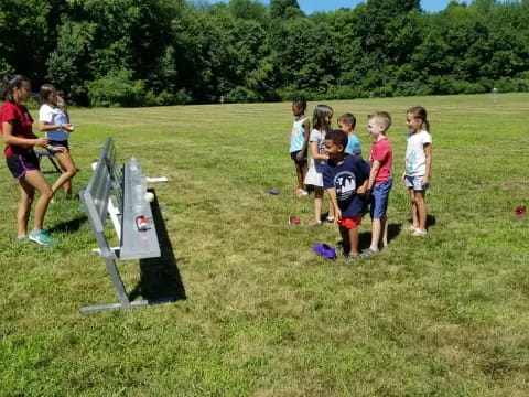 a group of kids playing in a grassy field