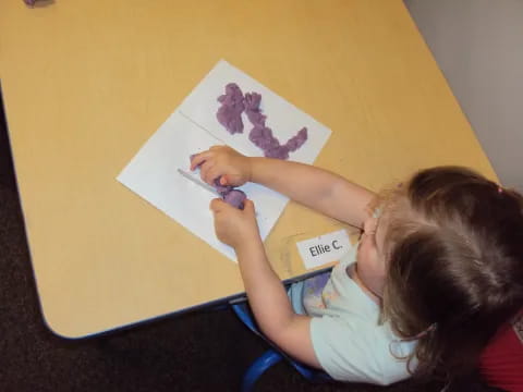 a girl drawing on a paper