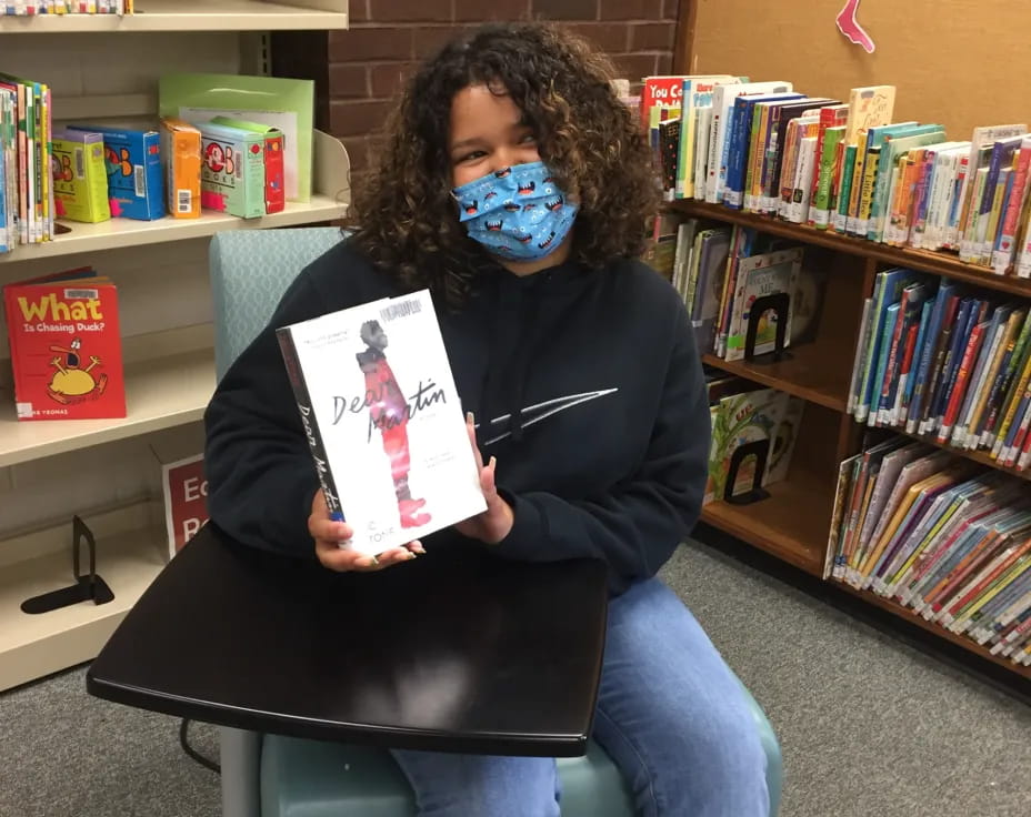 a person wearing a mask and holding a book