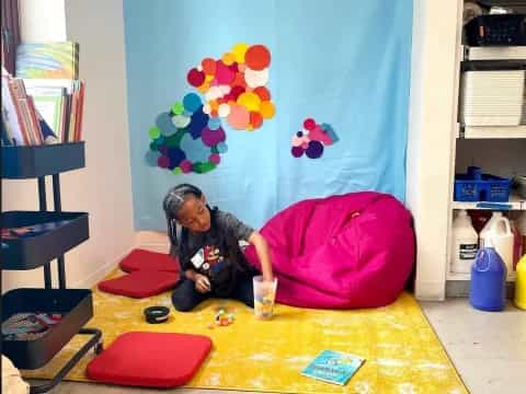 a child sitting on a colorful pillow