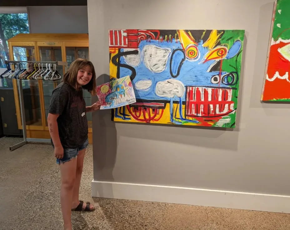 a person standing next to a painting