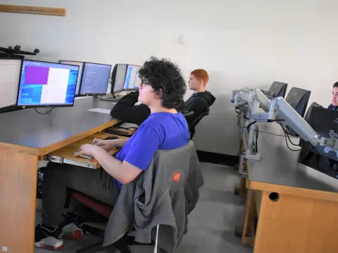a group of men sitting at desks with computers