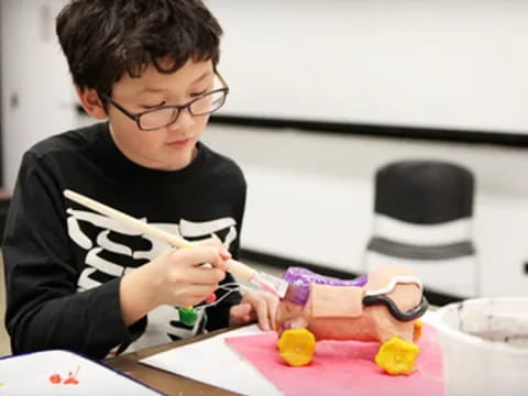 a boy painting with a brush