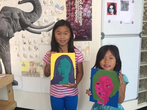 a couple of girls holding a drawing