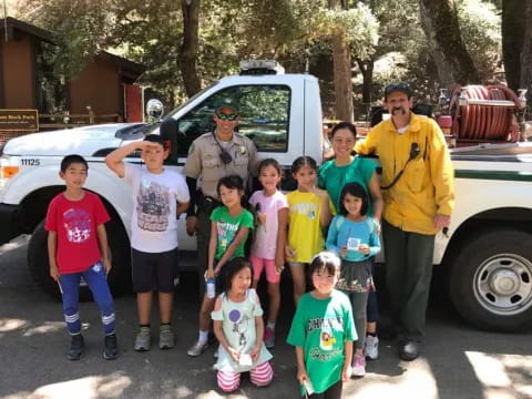 a group of people posing for a photo in front of a truck