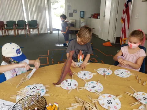 a group of children playing with paper plates on a table