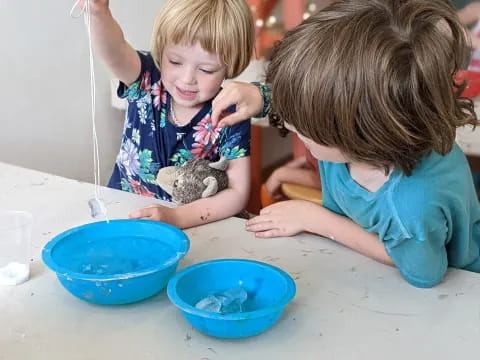 a couple of kids playing with blue bowls