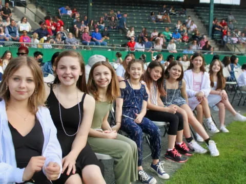 a group of girls sitting on a bench in a stadium