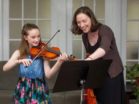 a person playing a violin next to a person playing a violin