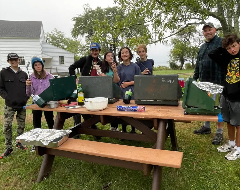 a group of people standing around a table outside