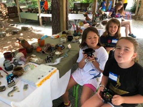 a group of children sitting at a table with a cake