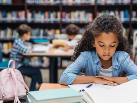 a young girl sitting at a desk