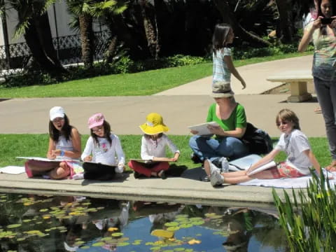 a group of people sitting on a bench next to a pond