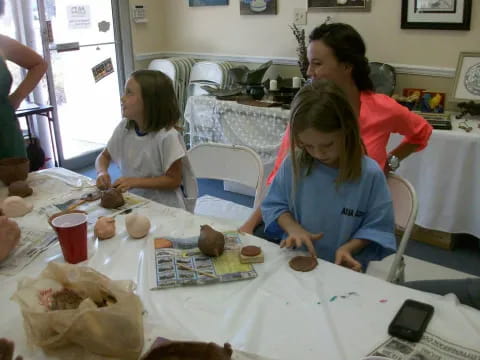 a person and a girl sitting at a table with food