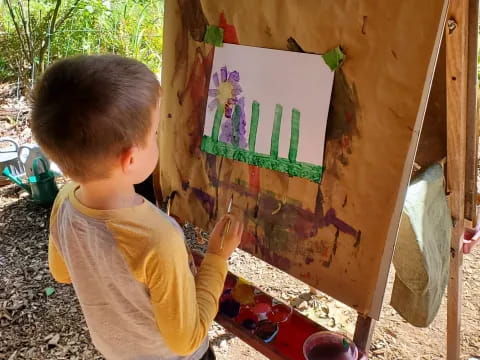 a child painting on a canvas