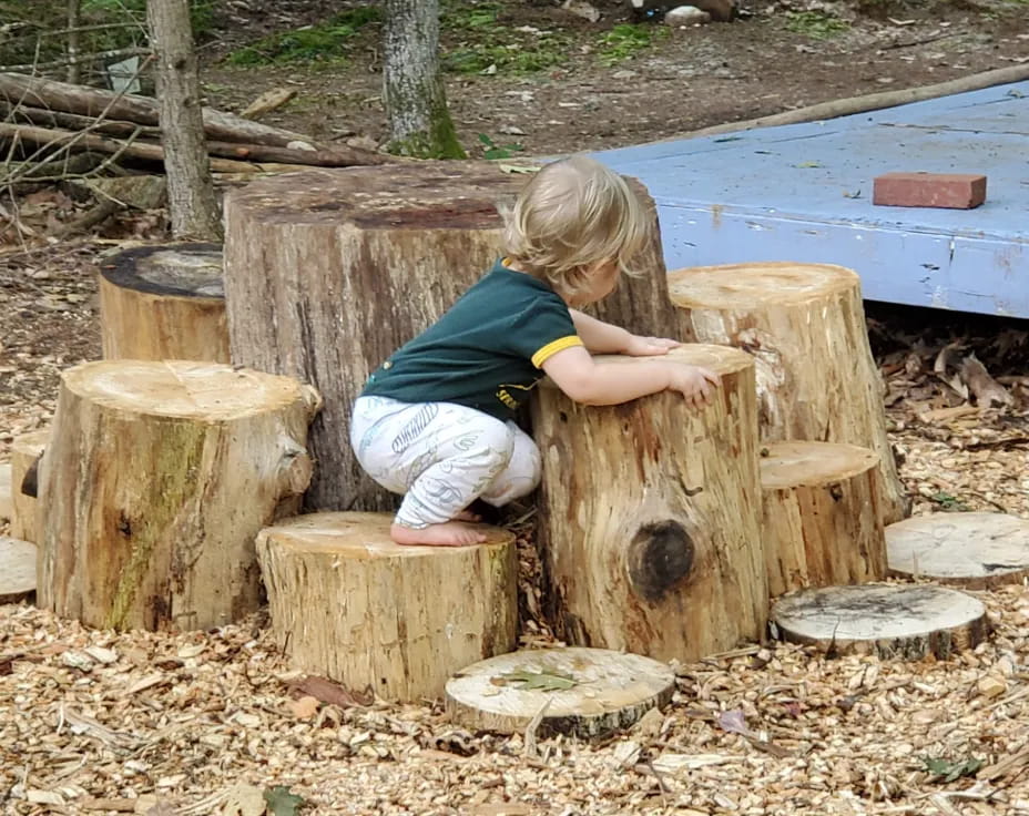 a child playing with a wooden bench