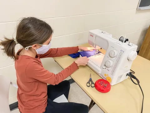 a person using a sewing machine