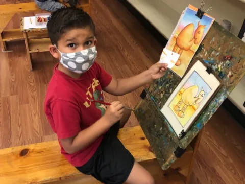 a boy painting on a canvas