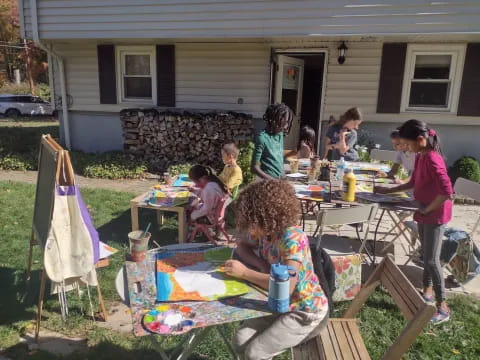 a group of people sitting around a table outside