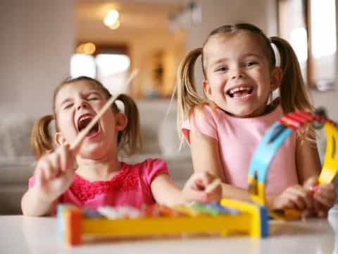 a couple of young girls playing with toys