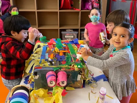 a group of children sitting at a table with toys