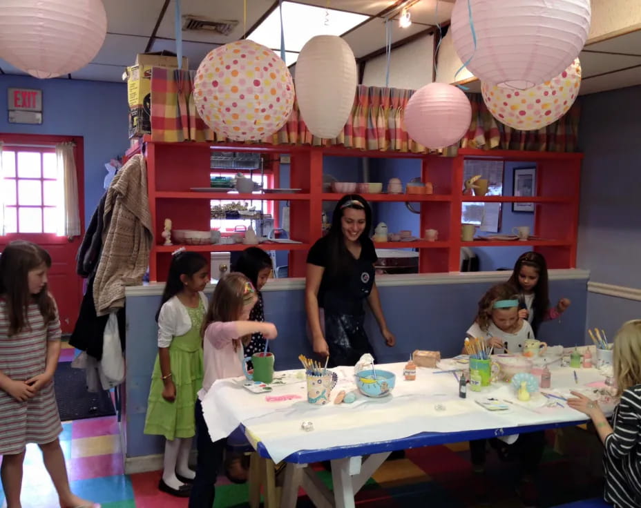 a group of people standing around a table with food on it