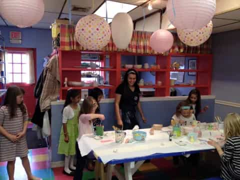 a group of people standing around a table with food on it