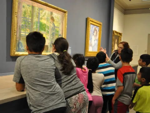 a group of people looking at a painting on the wall