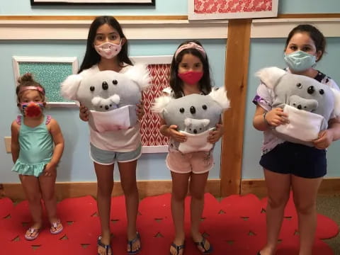 a group of children holding stuffed animals