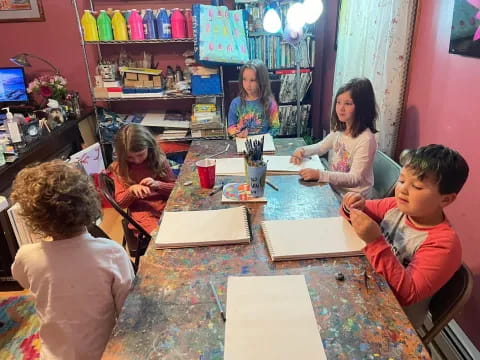 a group of children sitting around a table